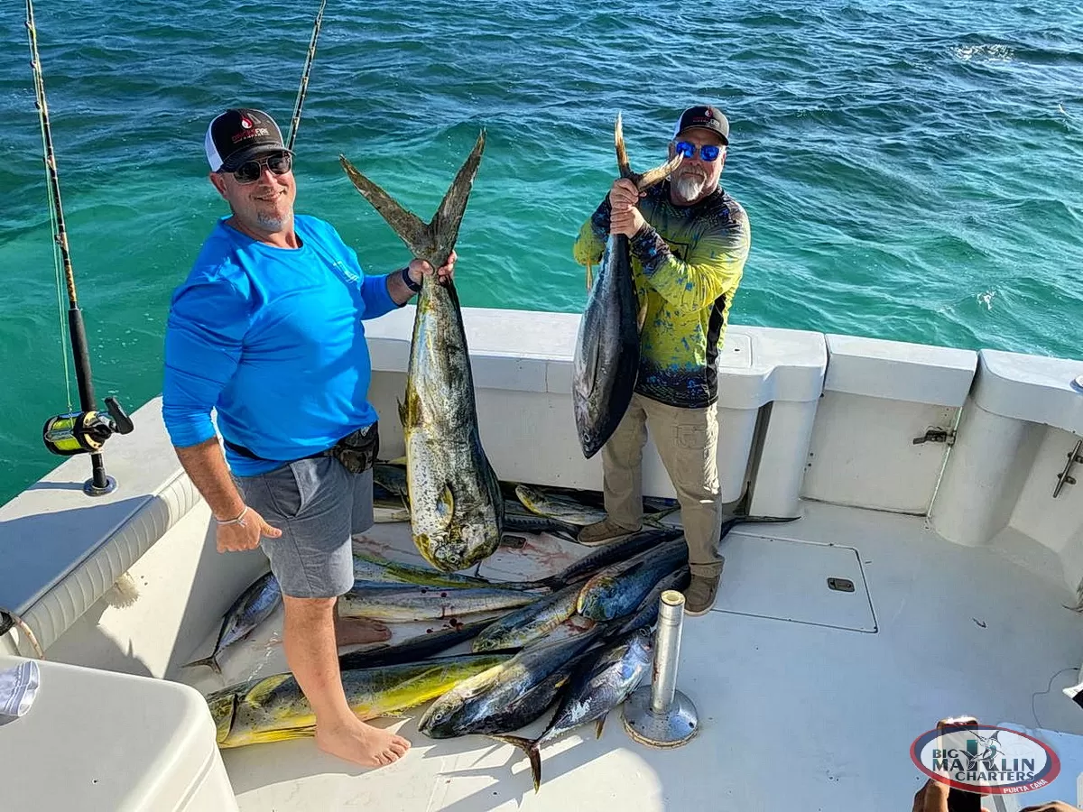 Group of friends smiling with multiple tuna catches after a successful offshore fishing adventure in Punta Cana.