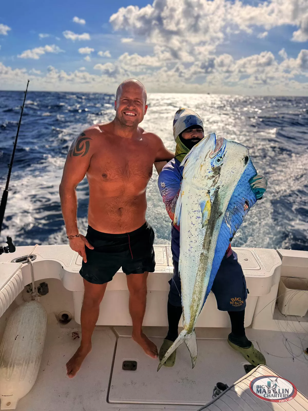 Smiling angler holding a large dorado (mahi-mahi) under the Caribbean sun in Punta Cana.